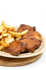 Stewed pork chops with french fries on the plate