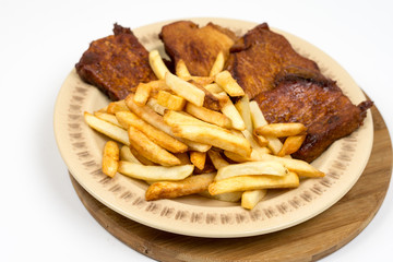 Baked pork chops with french fries served on the plate