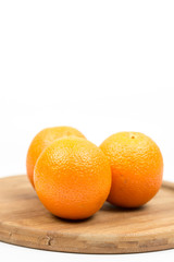 Three oranges on the wooden board with white background copy space