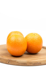 Three oranges on the wooden board with white background copy space