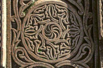 Part of a stone slab with carved on it a sign of eternity in frame with floral ornament