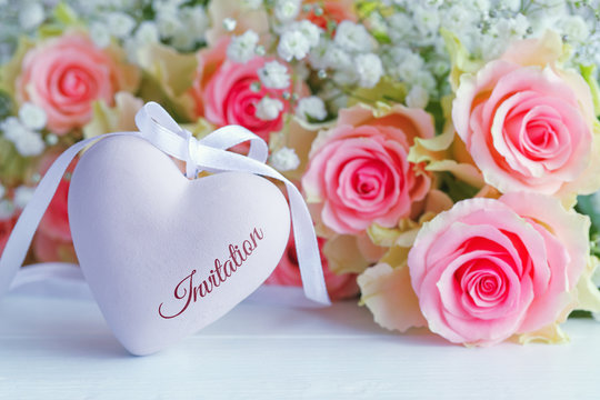 Decorative heart with a bouquet of roses on a wooden table