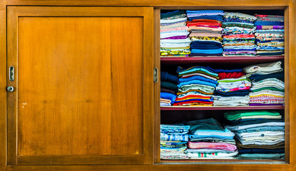Closet with clothes folded in orderly