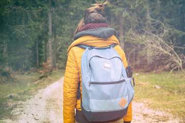 Girl hiking in nature and walking on a bright path.