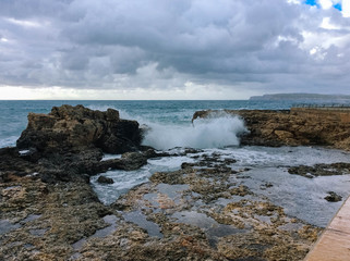 Big waves breaking on the shore with sea foam