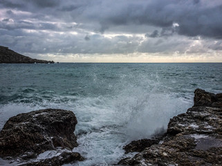 Big waves breaking on the shore with sea foam