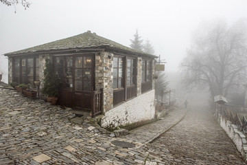 Fog and traditional stone building in Vizitsa village on mountain Pelion.Greece