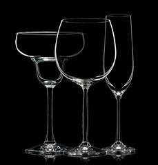 Silhouette of different glasses on black background.