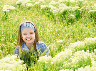 Happy smiling little girl on the meadow