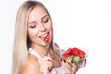 Young beautiful woman eats vegetable salad. Healthy eating. To be in shape.