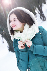 Beautiful young smiling woman in the park in winter sunny day.