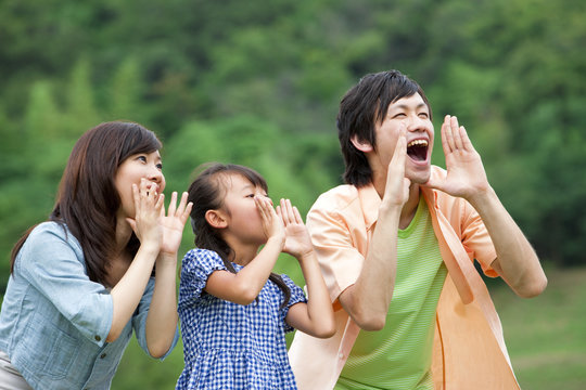 Family shouting in field, differential focus