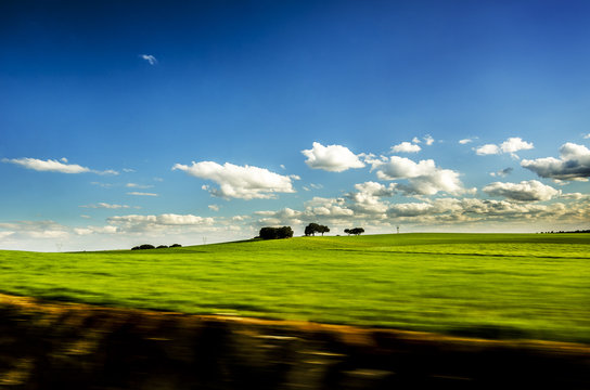 Vista de paisaje con cielo azul, nubes y pastos verdes