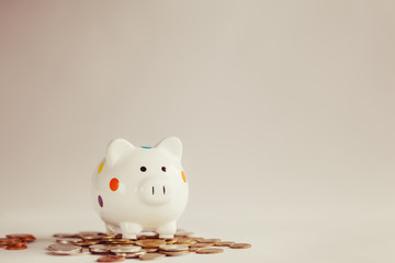 White piggy bank or money box with money coins © Volha Zaitsava