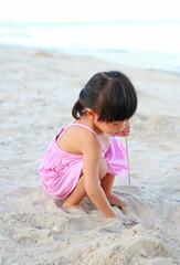Portrait Kid girl playing sand at the beach