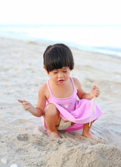 Portrait Kid girl playing sand at the beach