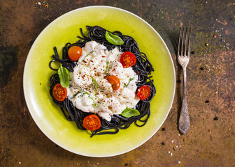 Pasta sepia with shrimps and salmon in cream sauce - Italian food.
