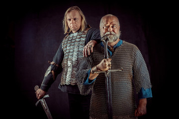 Two powerful knights with the swords on the dark background