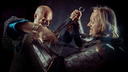 Dagger fight between two medieval knights on the dark background