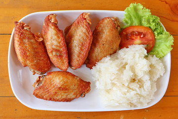buffalo chicken wings with sticky rice on white plate