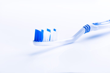 Toothbrush isolated on a white background with reflection. Blue plastic toothbrush. Concept of dental medicine.