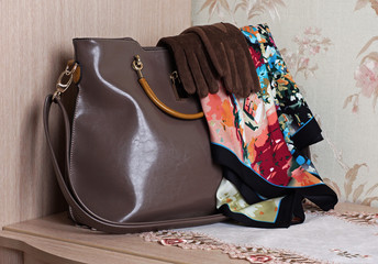 arrangement of beige leather bags and colorful scarves and gloves