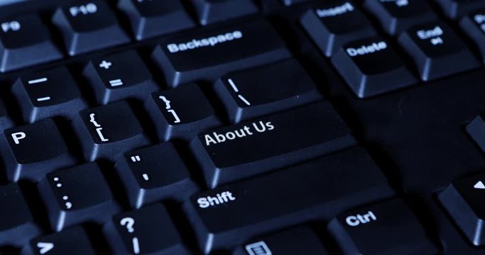 Video footage of male hand pressing an About Us button on the computer keyboard