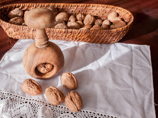 walnut  in a basket and wood nutcracker in a white tablecloth