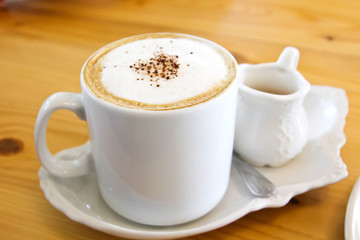 Hot coffee in a white cup on table