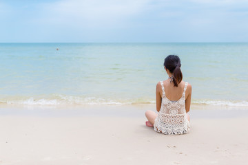 Fototapeta na wymiar Woman sitting on beach