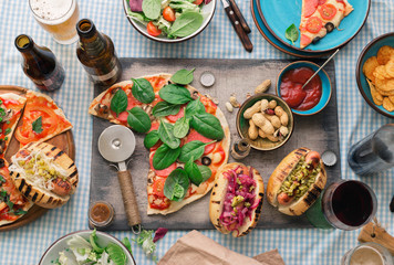 Dinner table with various food for company, top view