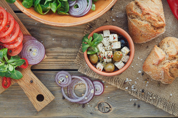Ingredients for vegetables salad on a wooden background.