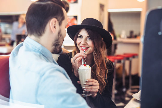 Couple Enjoying Milkshake and Chatting at Diner Restaurant
