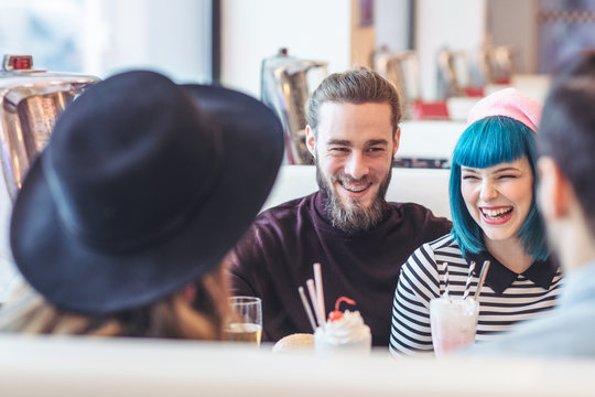 Friends Laughing at Coffee Shop - Powered by Adobe