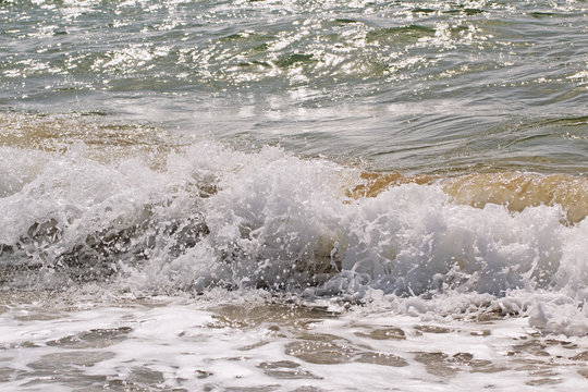 Fototapeta Waves on the Black Sea coast, a solar reflex on the surface, a brilliant dynamic foam background with a spray