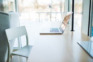 Close-up of comfortable working place in office with wooden table with laptop