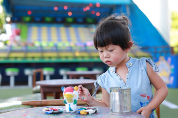 Child painting, Portrait little girl having fun to paint on stucco doll