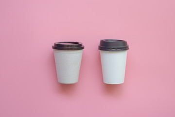 Flat lay design of two type of hot coffee cup on pink pastel background.