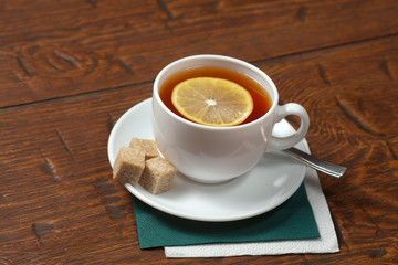 Obraz premium Cup of tea with lemon on a wooden table