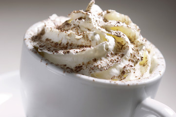 White cup of coffee with cream on top
