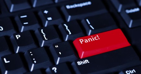 Video footage of human hand pushing a red Panic button on the computer keyboard