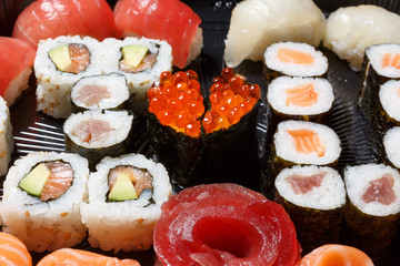 A large set of sushi and rolls view from above. A lot of food in one plate. Dishes from raw fish Japanese food.A dish in a romantic style. I love you. Heart with red fish caviar