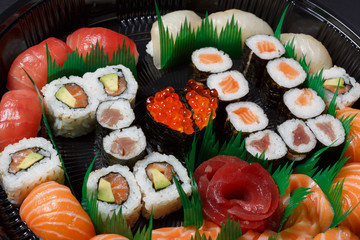 A large set of sushi and rolls view from above. A lot of food in one plate. Dishes from raw fish Japanese food.A dish in a romantic style. I love you. Heart with red fish caviar