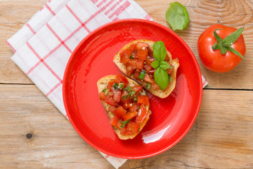 Bruschetta mit Tomaten auf einem Holzbrett