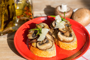 Bruschetta mit Pilzen auf einem Holzbrett