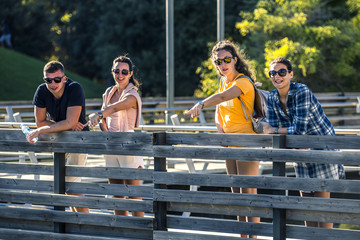 Group of young and attractive people is standing on bridge in park and pointing on something. Sunny day, Barcelona, Spain - 140774292