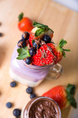 fruits with yogurt smoothie blueberries and strawberries in a glass on wooden background