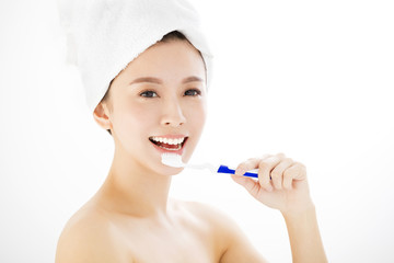 Young smiling woman brushing her teeth