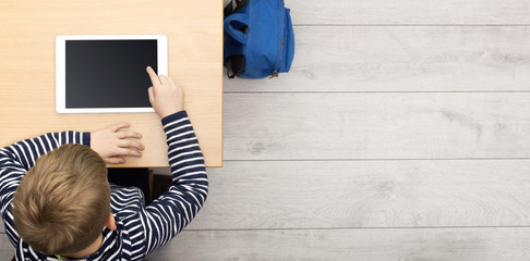 young kid at school behind desk