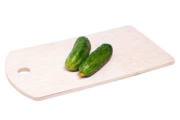 Огурцы на деревянной доске на белом фоне